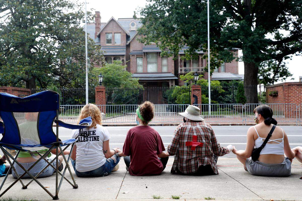 Protesters sit across the street from the N.C. Executive Mansion in Raleigh, N.C., Tuesday morning, June 30, 2020. They camped out overnight Monday to protest a new bill that further limits public access to death investigation records.