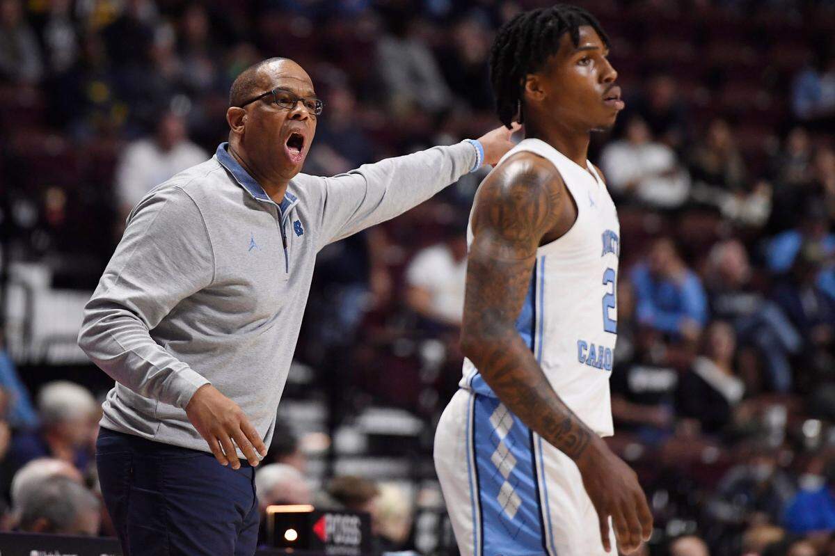 North Carolina head coach Hubert Davis, left, calls out to North Carolina’s Caleb Love (2), right, in the first half of an NCAA college basketball game against Tennessee, Sunday, Nov. 21, 2021, in Uncasville, Conn.