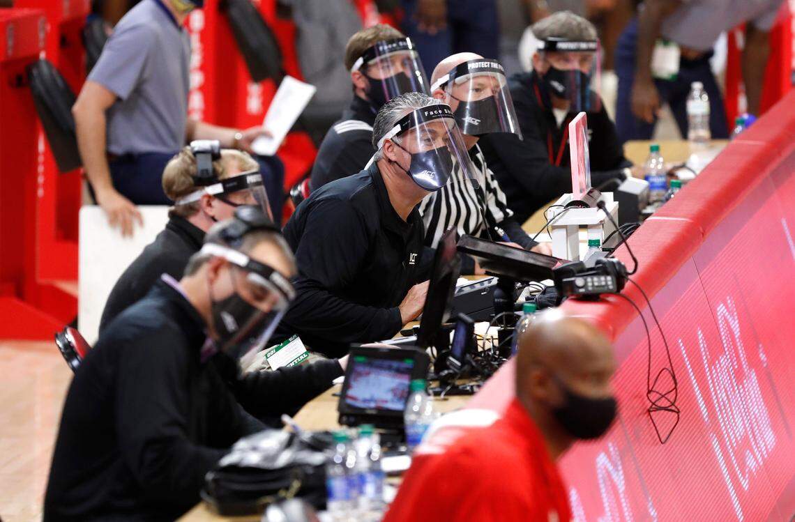 Officials sitting at the scorer’s table wear face shields during N.C. State’s 95-61 victory over Charleston Southern in the Wolfpack Invitational at Reynolds Coliseum in Raleigh, N.C., Wednesday, Nov. 25, 2020.