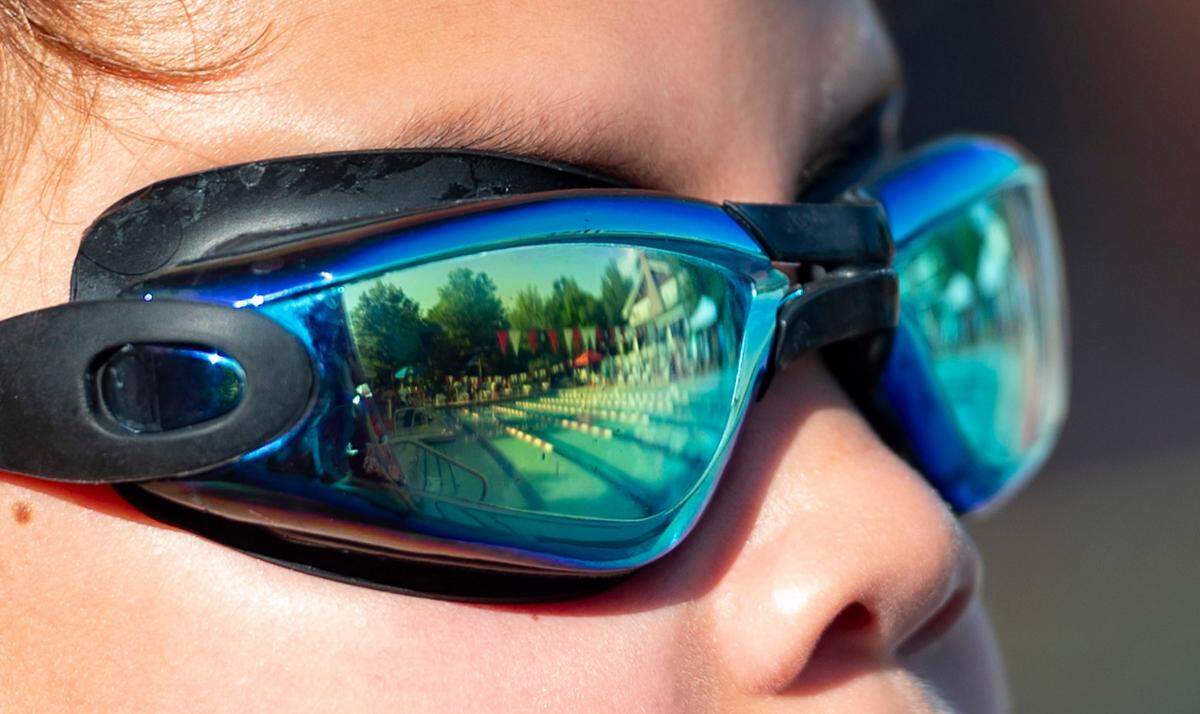 The pool reflects in Mason Wimpey’s goggles as he approaches the pool to compete in the swim meet against the Scottish Hills Sea Lions on Tuesday, June 25, 2024.