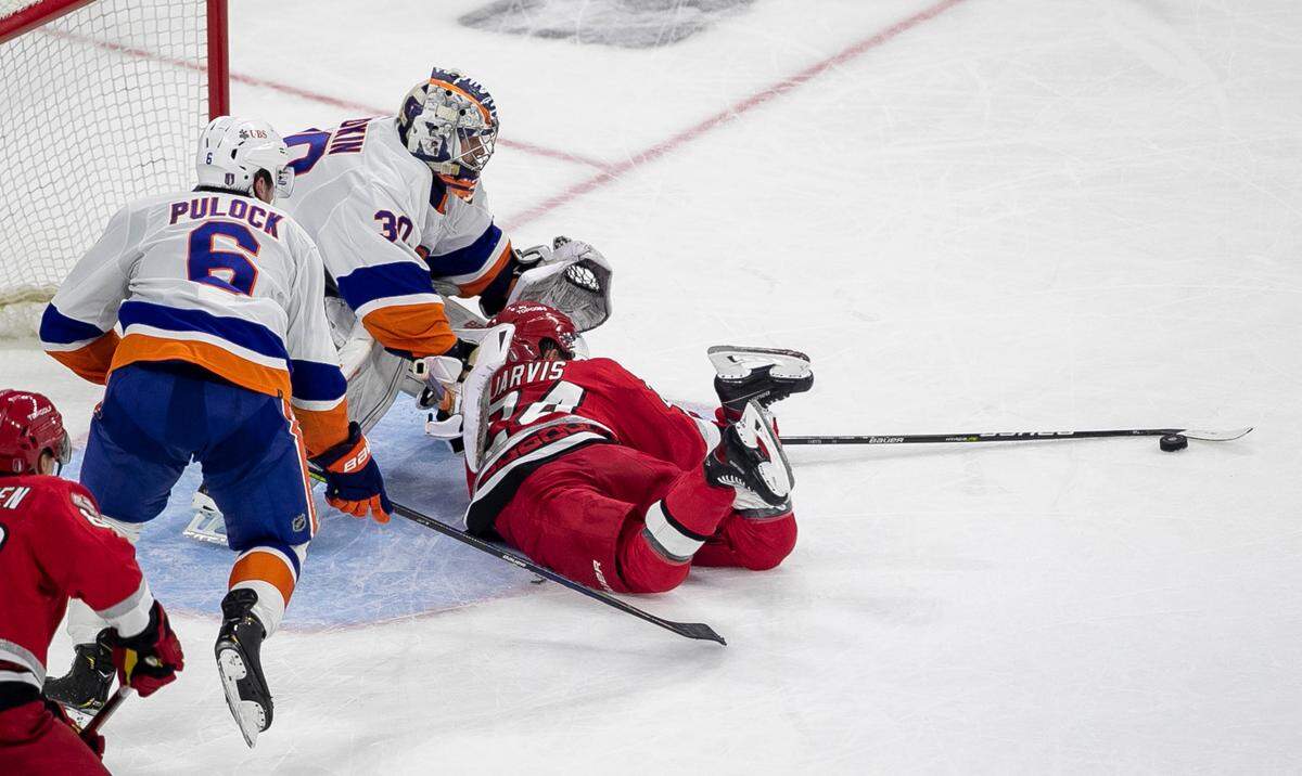 The Carolina Hurricanes Seth Jarvis (24) tries to get his stick on the puck in front of New York Islanders goalie Ilya Sorokin (30) in the third period during Game 2 of their Stanley Cup series on Wednesday, April 19, 2023 at PNC Arena in Raleigh, N.C.