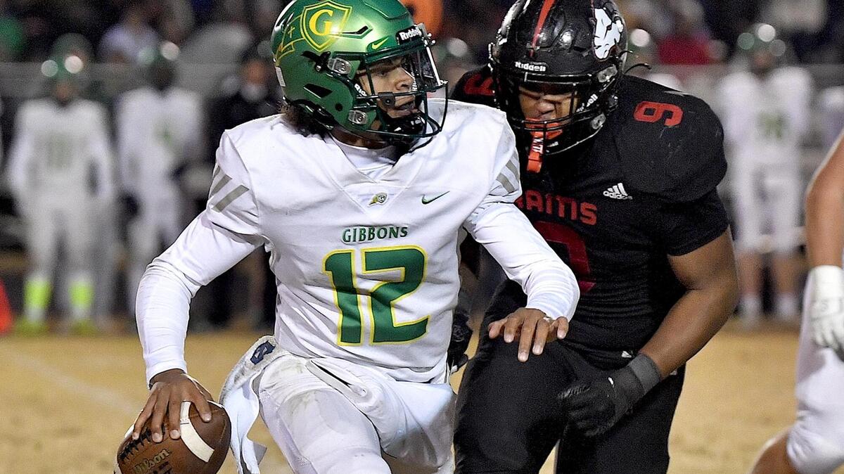 Cardinal Gibbons quarterback Gannon Jones (12) looks to pass against pressure from Rolesville’s Russell Sykes (9) during the second half. The Rolesville Rams and the Cardinal Gibbons Crusaders met in the fourth round of the NCHSAA 4A Football Playoffs in Raleigh, N.C. on November 24, 2023.