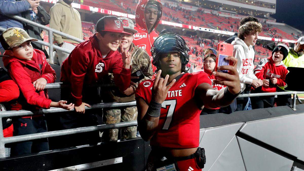 N.C. State quarterback MJ Morris takes a selfie with fans as he leaves the field after the Wolfpack’s 20-6 victory over Miami at Carter-Finley Stadium in Raleigh, N.C., Saturday, Nov. 4, 2023.