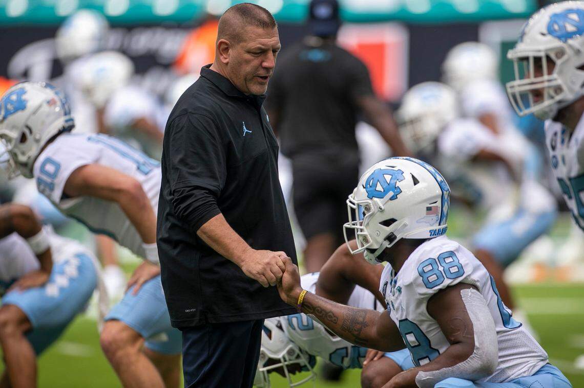North Carolina offensive coordinator Phil Longo talks with Kamari Morales (88) as the Tar Heels warm up fro their game against Miami on Saturday, October 8, 2022 at Hard Rock Stadium in Miami Gardens, Florida.