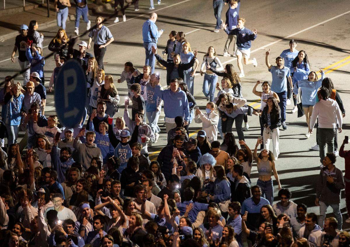 Tar Heel fans rush towards the intersection of Franklin and Columbia Streets in Chapel Hill, N.C. to celebrate UNC’s win against Duke in the Final Four on Saturday, April 2, 2022.
