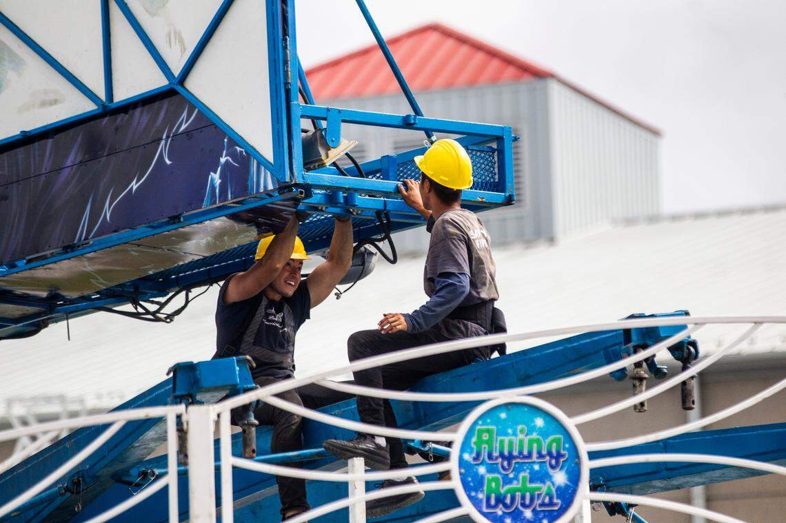 Workers assemble the Flying Bobs ride Tuesday, Oct. 12, 2021 at the NC State Fair in Raleigh. The North Carolina fair opens on Thursday and inspectors with the labor department must insure nearly 100 rides meet safety standards.