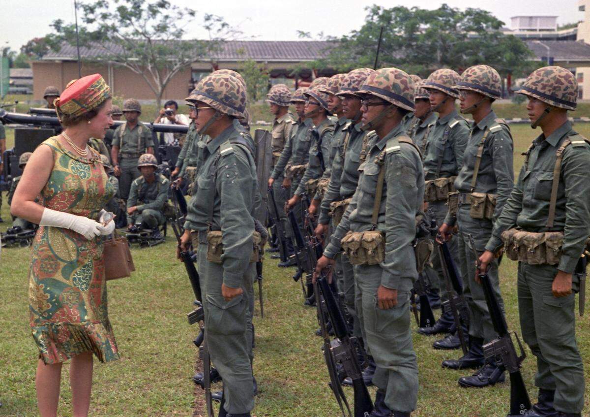 Queen Elizabeth II talks to troops at the Singapore Armed Forces training institute during her visit on February 19, 1972. The Queen watched a mock battle demonstration.
