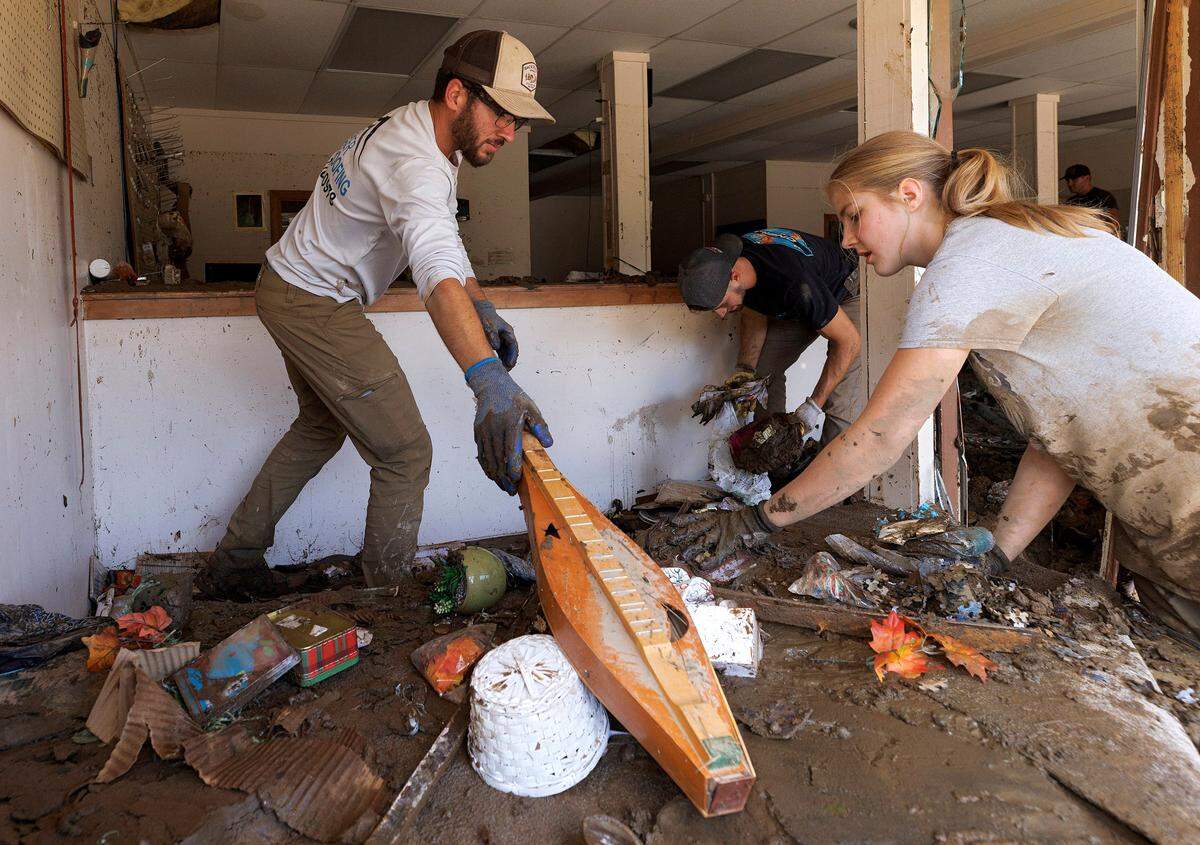 Andrew Zook, left, helps to clear instruments and other items from the mud inside Majestic Music in downtown Spruce Pine, N.C. on Thursday, Oct. 3, 2024, days after Hurricane Helene brought heavy flooding to the area.