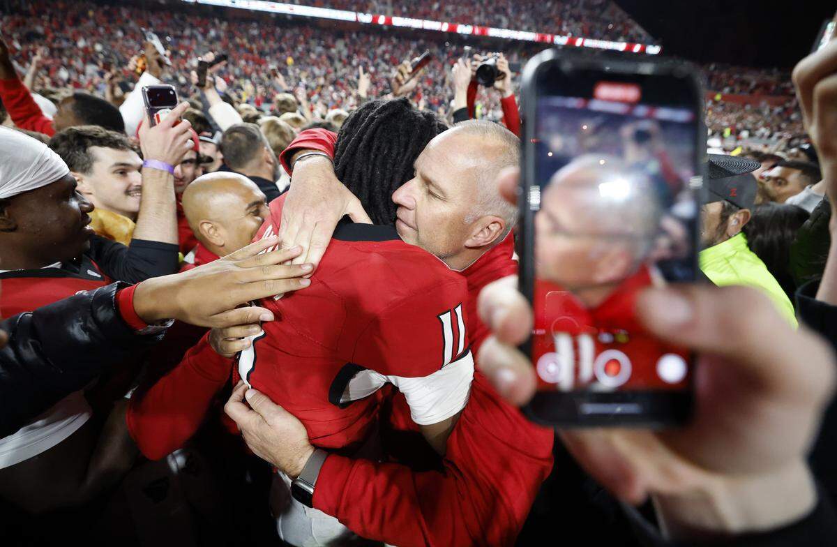 N.C. State head coach Dave Doeren hugs quarterback CJ Bailey (11) after N.C. State’s 48-36 victory over Georgia Tech at Carter-Finley Stadium in Raleigh, N.C., Saturday, Nov. 1, 2025.