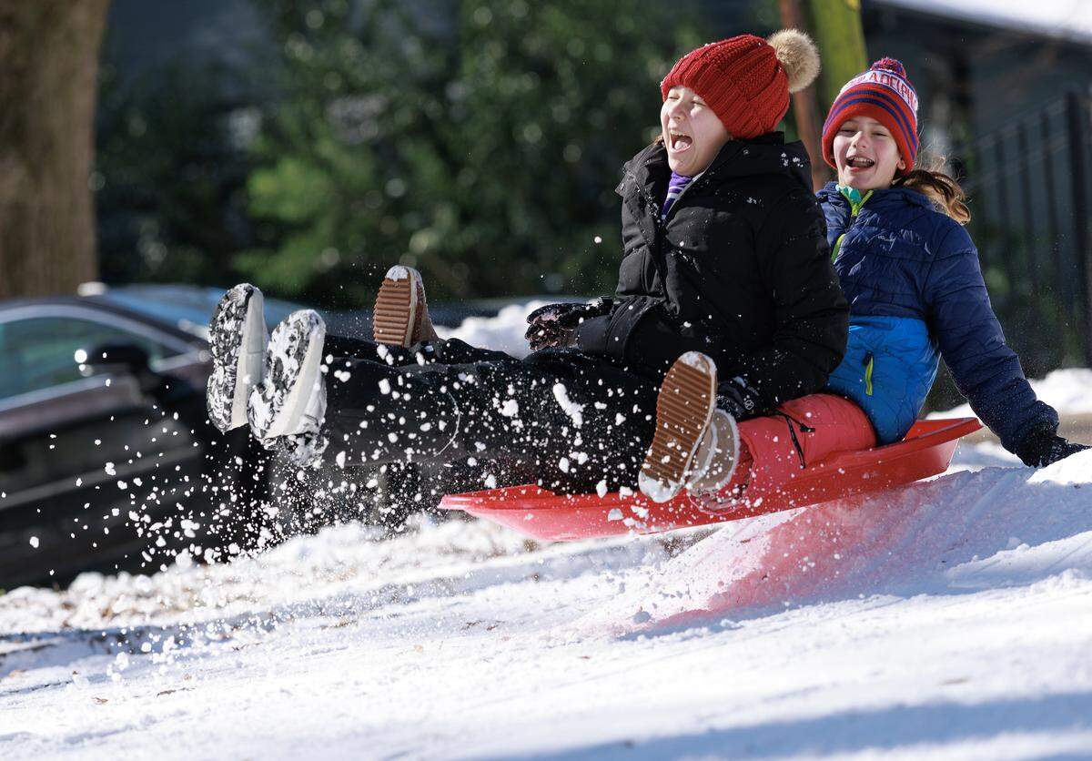 Addison Hsia, 12, and Blythe Virdin, 12, sled down Demerius Street on Sunday, Feb. 1, 2026, in Durham, N.C.