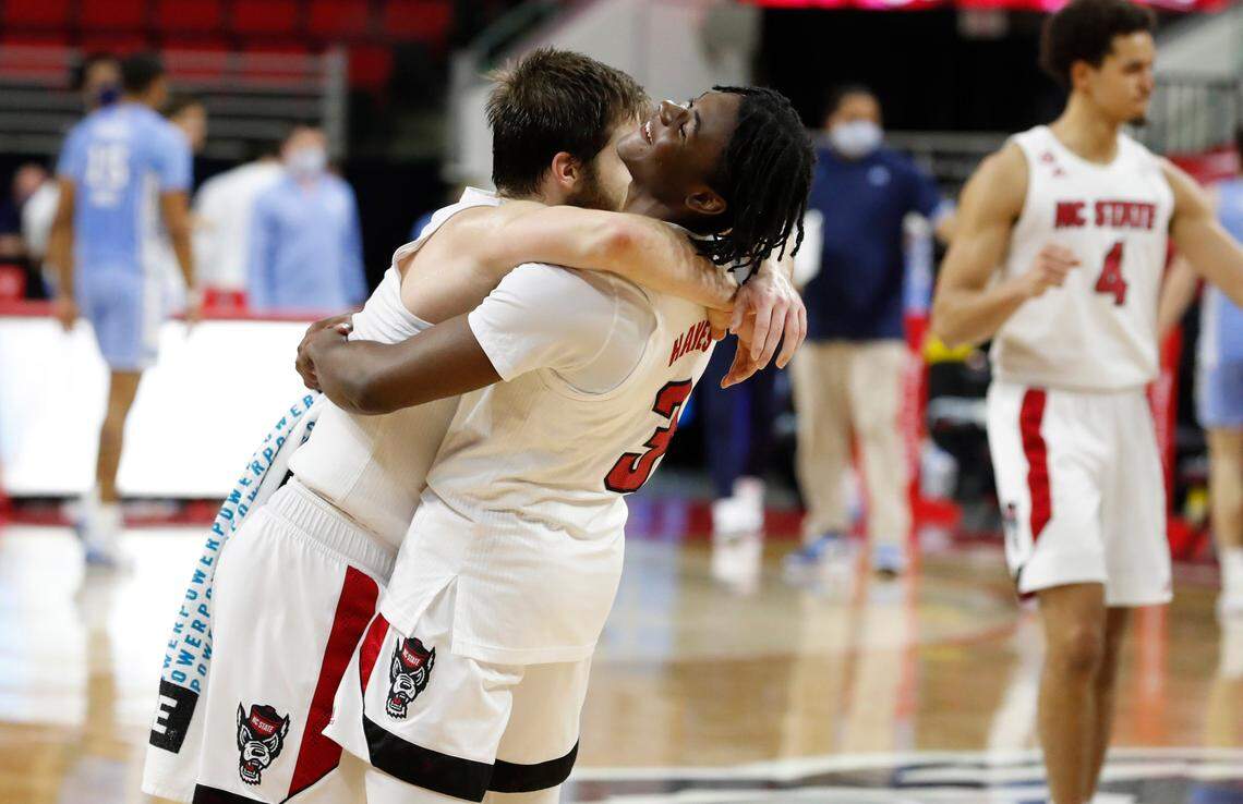 N.C. State’s Cam Hayes (3) celebrates with Braxton Beverly (10) after N.C. State’s 79-76 victory over UNC at PNC Arena in Raleigh, N.C., Tuesday, December 22, 2020.