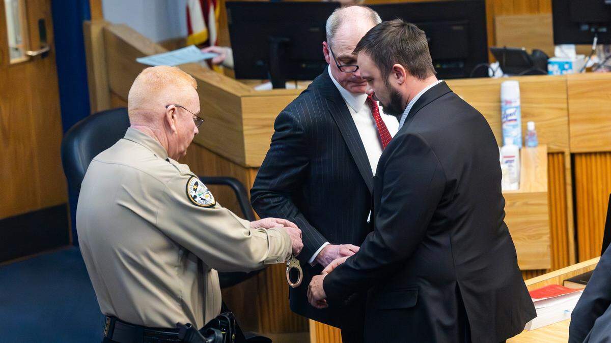 Ronald Johnson, an embattled Johnston County school board member, right, is handcuffed and led from a courtroom by a bailiff after a jury found him guilty of extortion on Friday, Jan. 17, 2025. Johnson was sentenced to six to 17 months in prison on felony extortion charges. He also received a suspended sentence of 16 to 29 months for obstruction of justice and failure to discharge his duties.