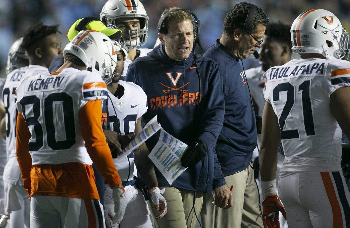 Virginia head coach Bronco Mendenhall talks with his players during a time out in the fourth quarter against North Carolina on Saturday, November 2, 2019 at Kenan Stadium in Chapel Hill, N.C.
