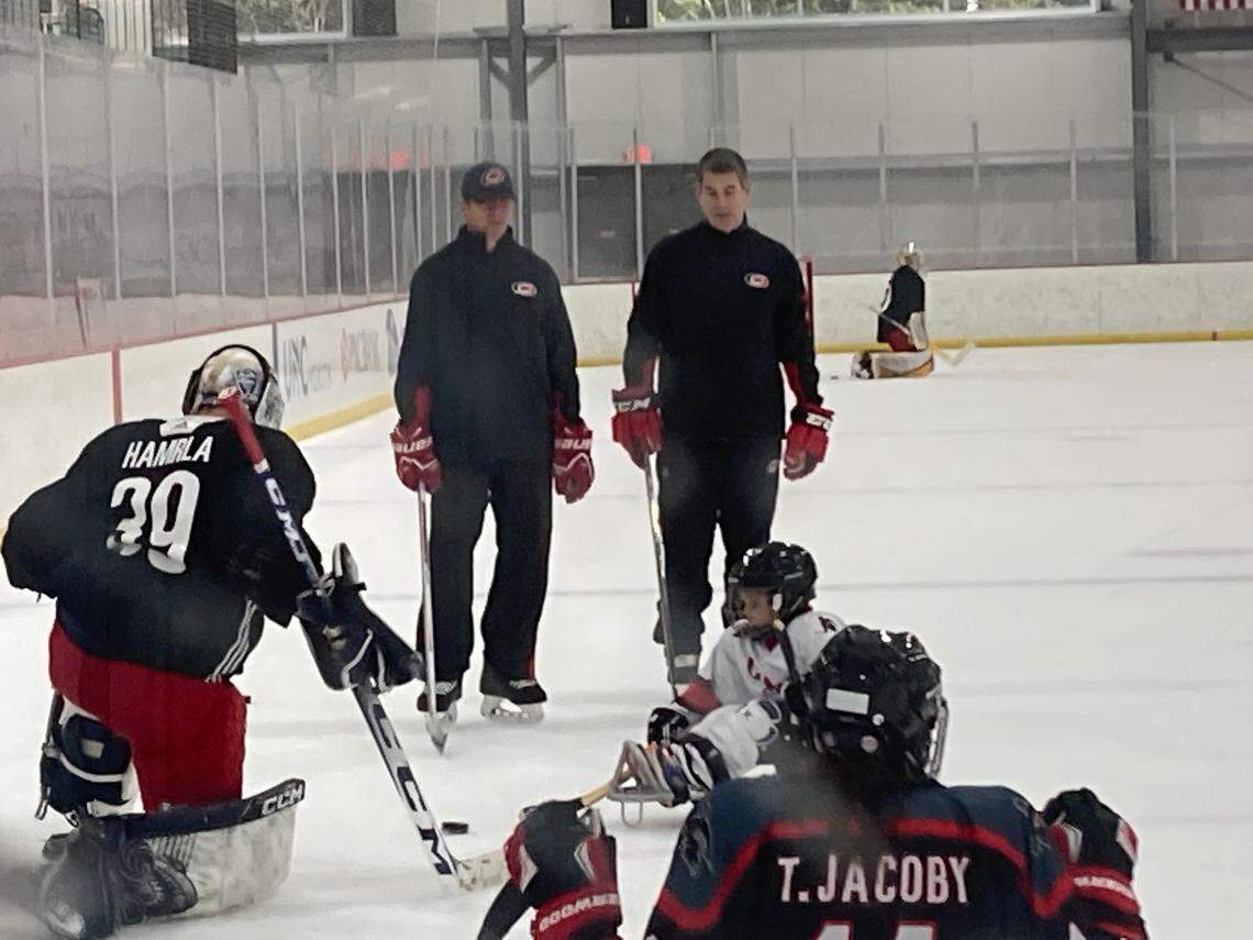 Carolina Hurricanes coach Rod Brind’Amour, left, and goalie development coach Jason Muzzatti watch the sled hockey game Wednesday, July 12, 2023 at development camp.