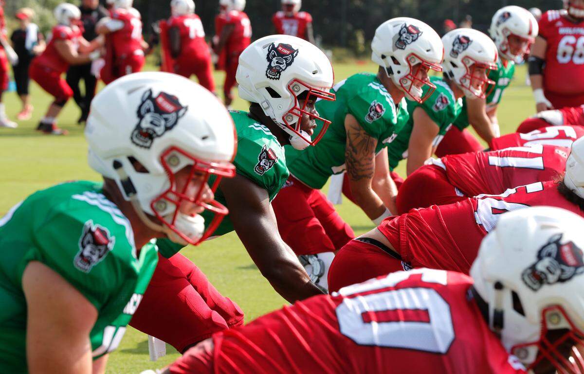N.C. State quarterbacks Matthew McKay (7), center, along with Devin Leary (13), left and Bailey Hockman (16), right, prepare to take a snap during the Wolfpack’s practice in Raleigh, N.C. Tuesday, August 6, 2019.
