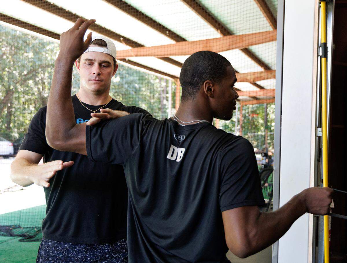 Matt Solter, Director of Performance at 8ctane Baseball, helps Daniel Brown with a shoulder stability exercise on Thursday, June 19, 2025, in Raleigh, N.C. 