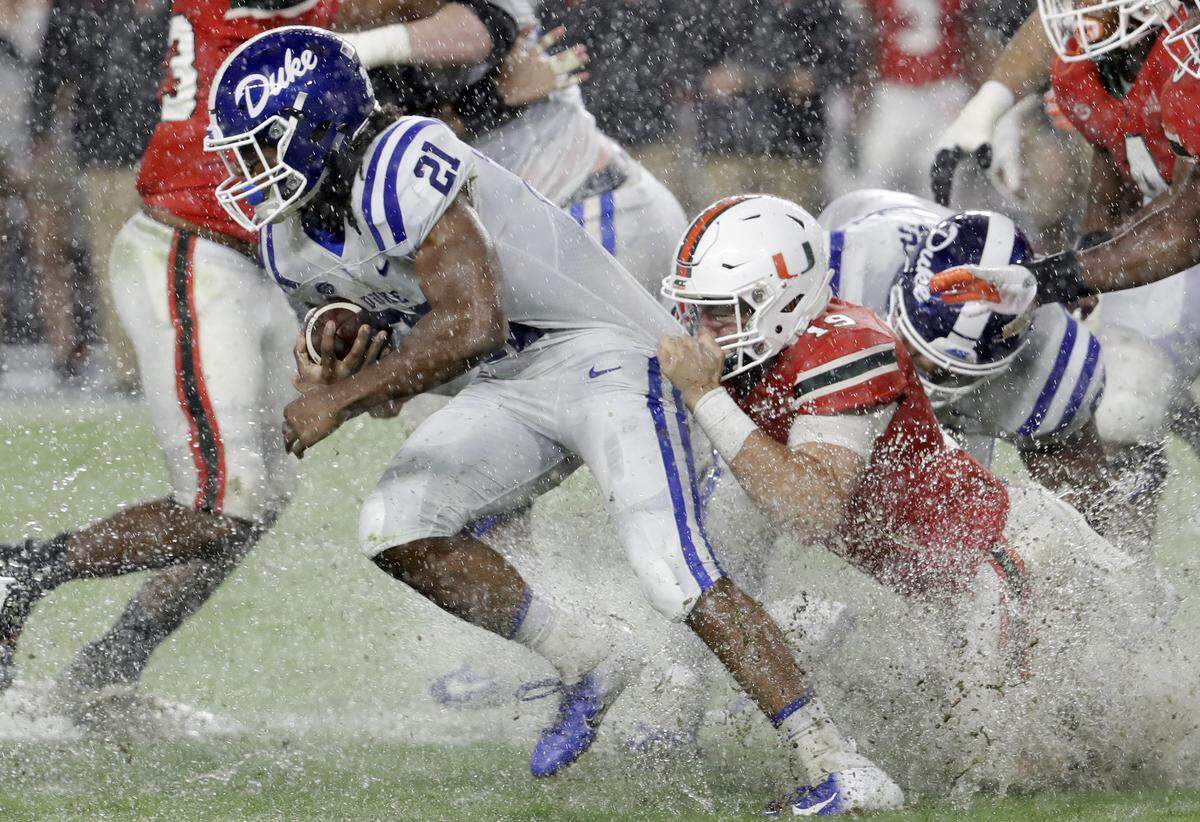 Miami defensive lineman Scott Patchan (19) attempts to tackle Duke running back Mataeo Durant (21) during the first half.