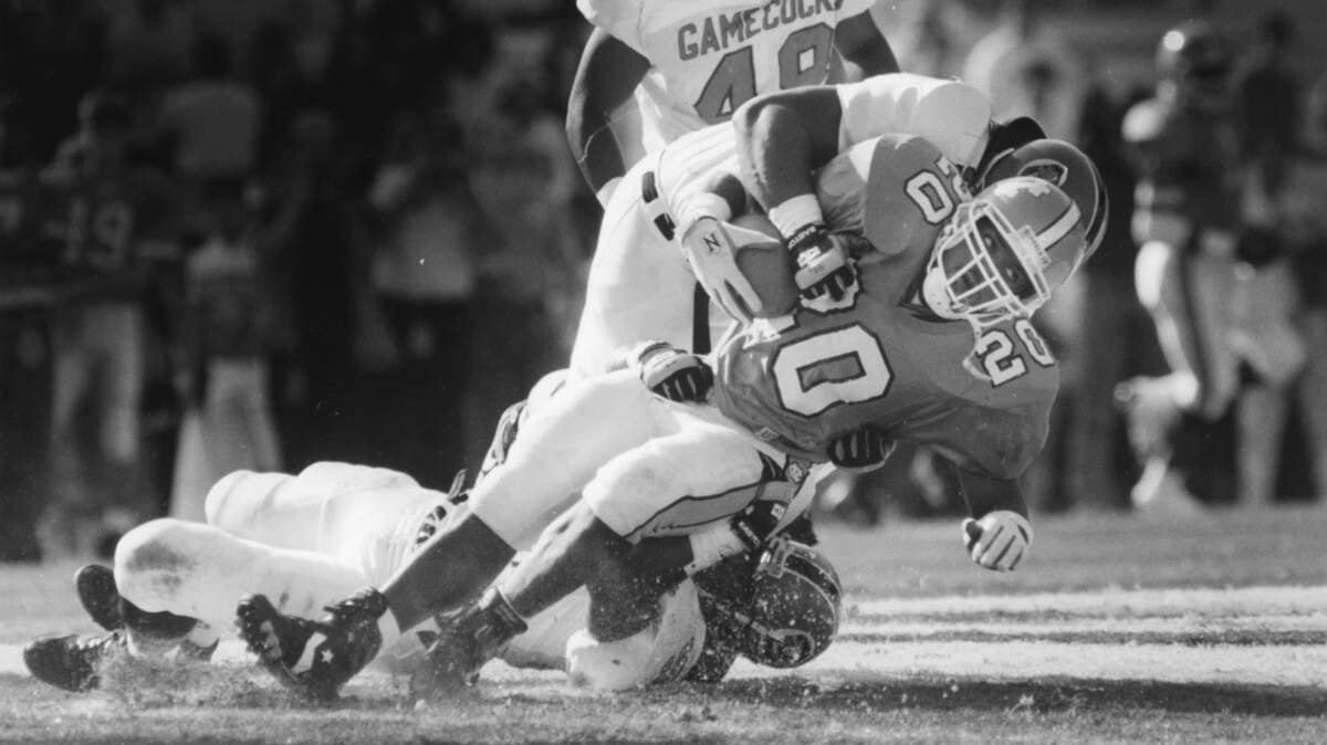 UNC’s Natrone Means gets hit by USC’s Keith Franklin (on his back) and Chris Rumph (at his feet) as he runs near the goal line in a 1991 game.