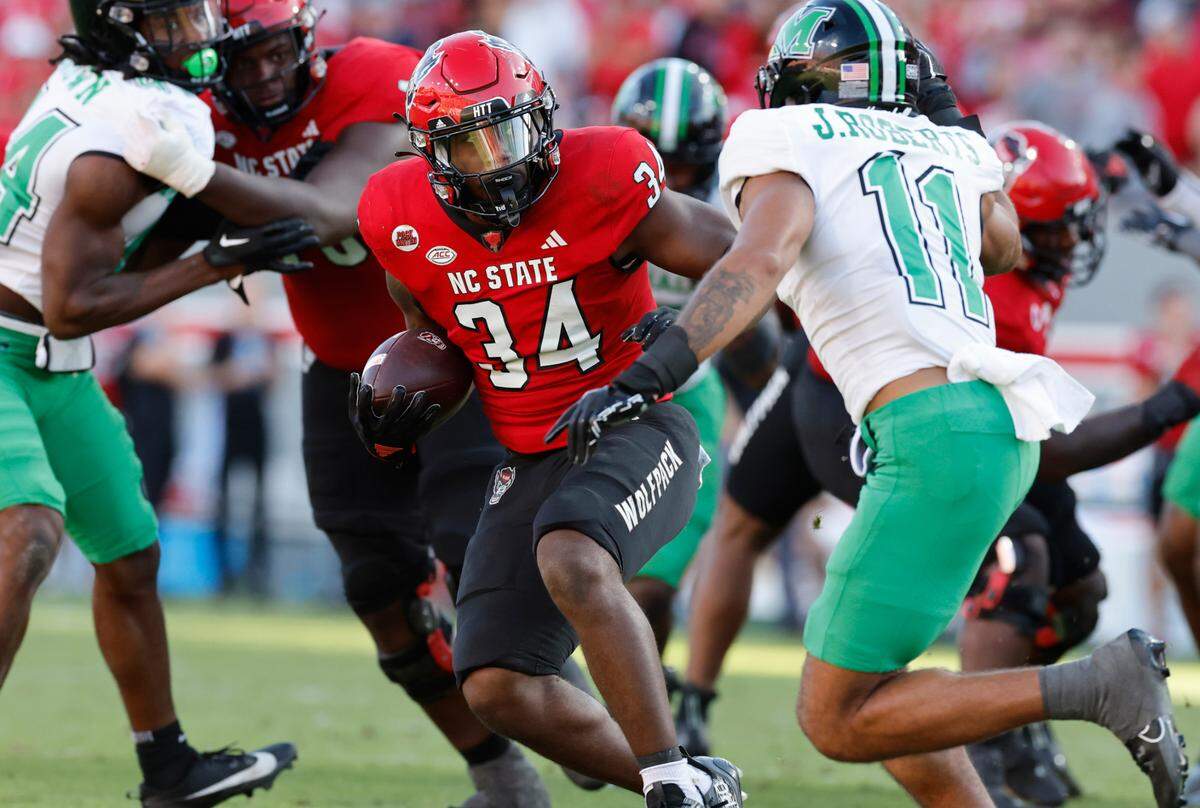 N.C. State running back Delbert Mimms III (34) makes Marshall’s Kerion Martin (22) miss on an 18-yard run during the second half of N.C. State’s 48-41 victory over Marshall at Carter-Finley Stadium in Raleigh, N.C., Saturday, Oct. 7, 2023.
