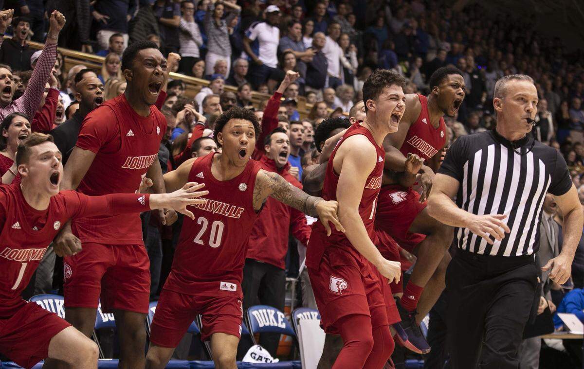Louisville’s Josh Nickleberry (20) and Quinn Slazinski (11) lead the cheers on the Cardinals’ bench as they secure a 79-73 victory over Duke on Saturday, January 18, 2020 at Cameron Indoor Stadium in Durham, N.C.