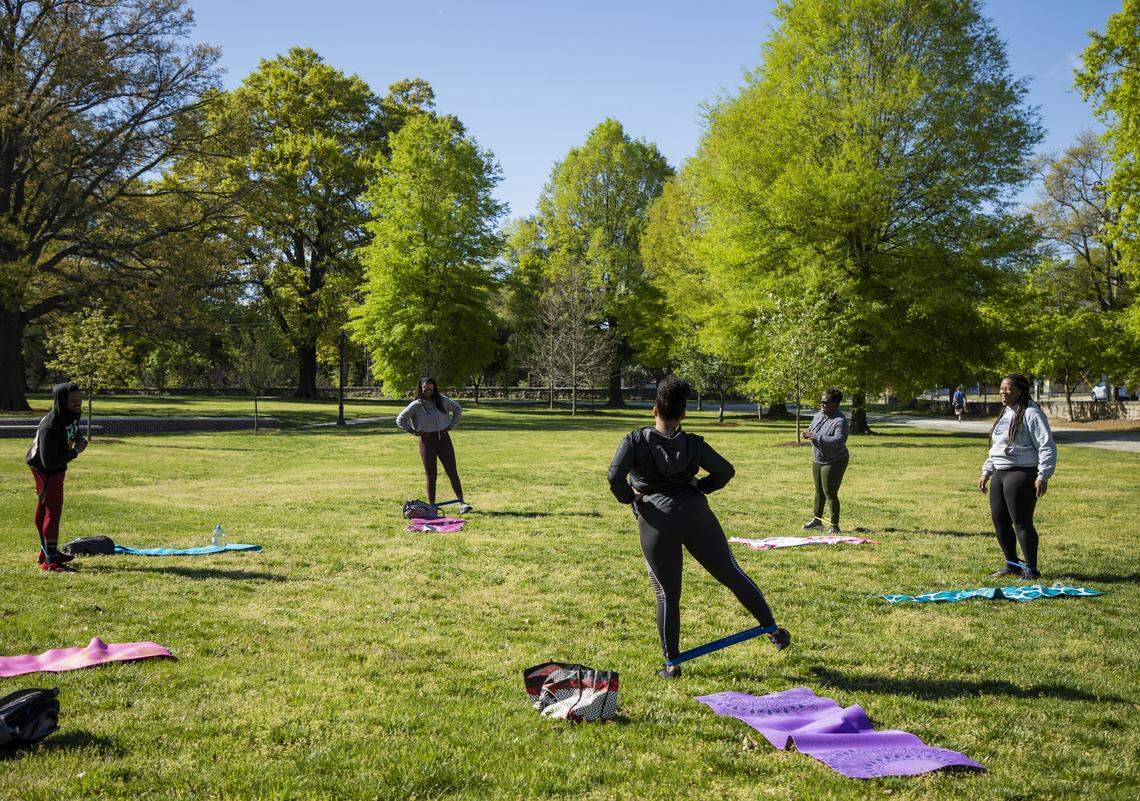 A group of seven people who normally exercise at Prime Athletics Trainings take their work out outside on Saturday, Apr. 4, 2020, in Durham, N.C. Gyms and fitness centers have been closed to prevent the spread of the coronavirus. They will stay closed in North Carolina’s Phase Two.