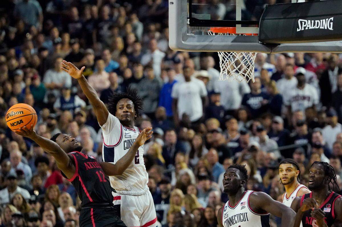 San Diego State Aztecs guard Darrion Trammell (12) shoots the ball as Connecticut Huskies guard Tristen Newton (2) defends during the second half in the national championship game of the 2023 NCAA Tournament at NRG Stadium.