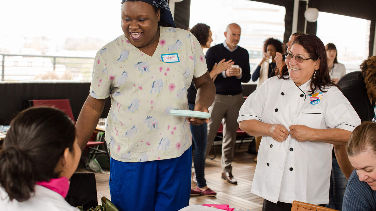 Bridgette Harper-Reid, left, who works at Creekside Elementary School in Durham, and Nora Polanco of food truck So Good Pupusas take part in a kickoff for Durham Bowls on Monday, April 16, 2018.