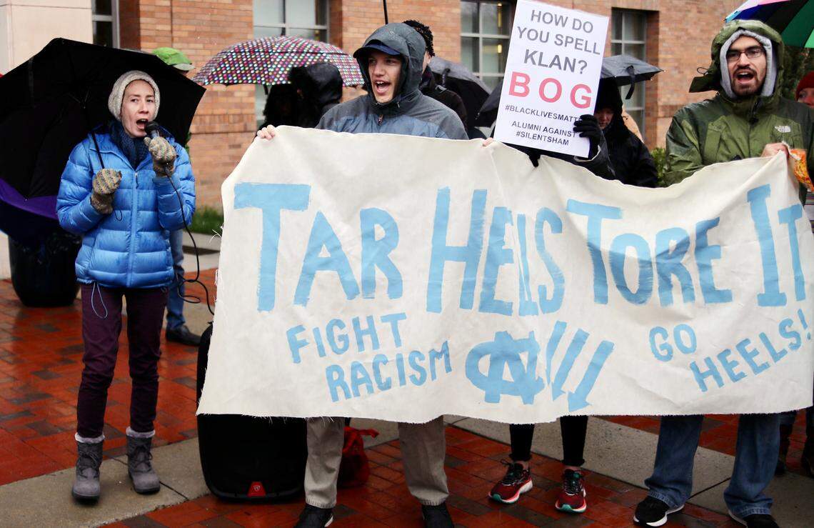 Lindsay Ayling speaks to the crowd of protesters while others hold sings and chant during protests over the recent Silent Sam deal made by the UNC Board of Governors.