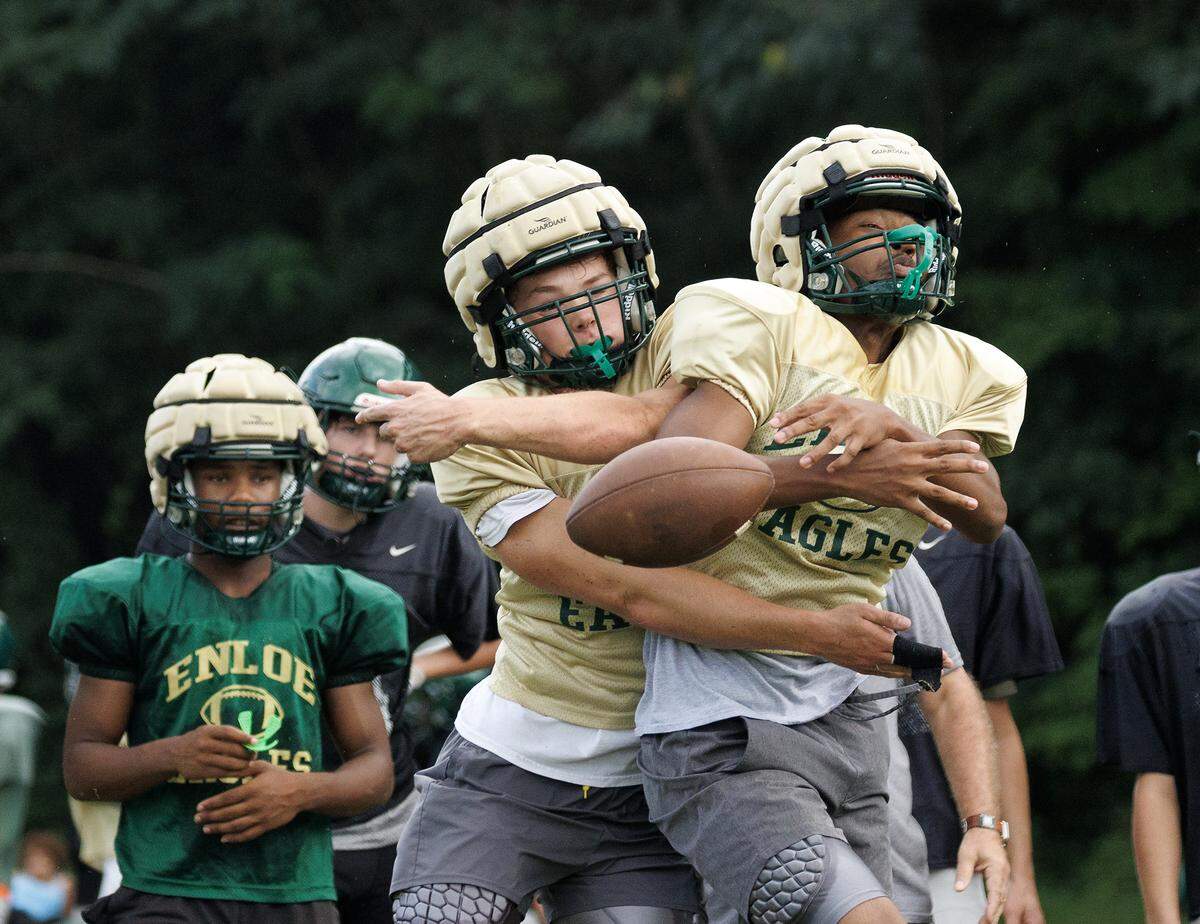 Enloe High School junior George Hill and senior Kobe Thomas jostle for the ball while running a drill during practice on Monday, Aug. 18, 2025, in Raleigh, N.C.