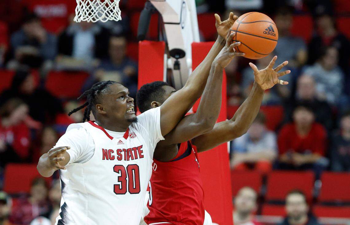 N.C. State’s D.J. Burns Jr. (30) knocks the rebound away from Louisville’s Brandon Huntley-Hatfield (5) during the first half of N.C. State’s game against Louisville at PNC Arena in Raleigh, N.C., Thursday, Dec. 22, 2022.