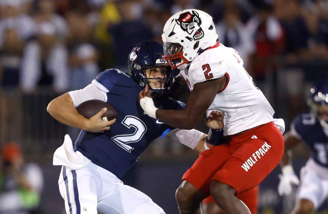 N.C. State linebacker Jaylon Scott (2) tackles Connecticut quarterback Joseph Fagnano (2) during the first half of N.C. State’s game against UConn at Rentschler Field in East Hartford, Conn. Thursday, August 31, 2023.