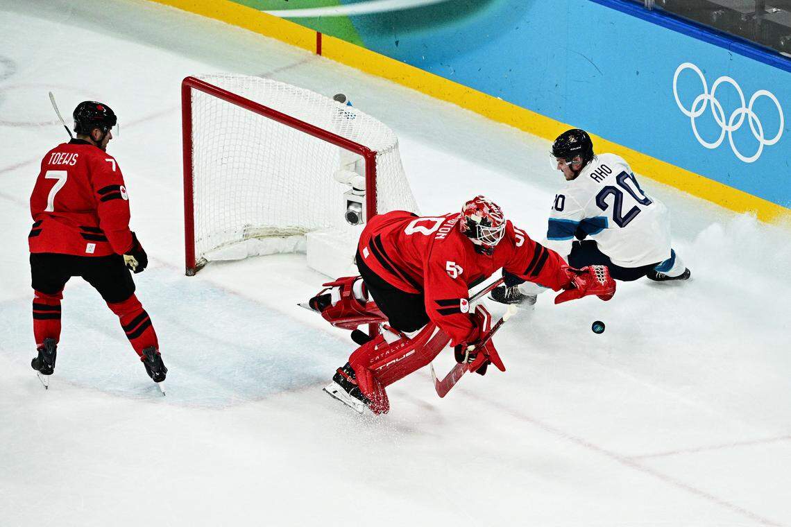 Canadian goalie Jordan Binnington dives for the puck as he defends against Finland's Sebastian Aho during the men's semifinal between Canada and Finland at the Milano Santagiulia Ice Hockey Arena during the Milano Cortina 2026 Winter Olympic Games in Milan, on Feb. 20, 2026.