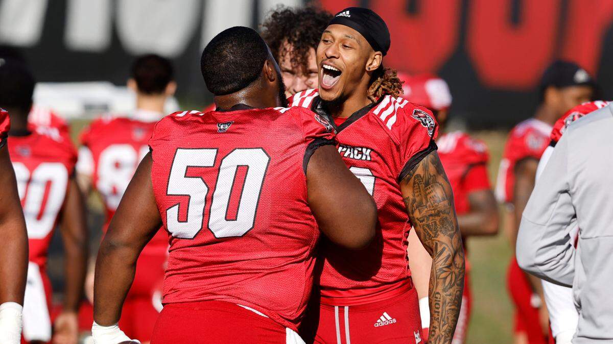 N.C. State wide receiver Devin Carter (88) greets center Grant Gibson (50) at the start of the first day of the Wolfpack’s spring football practice in Raleigh, N.C., Wednesday, March 2, 2022.