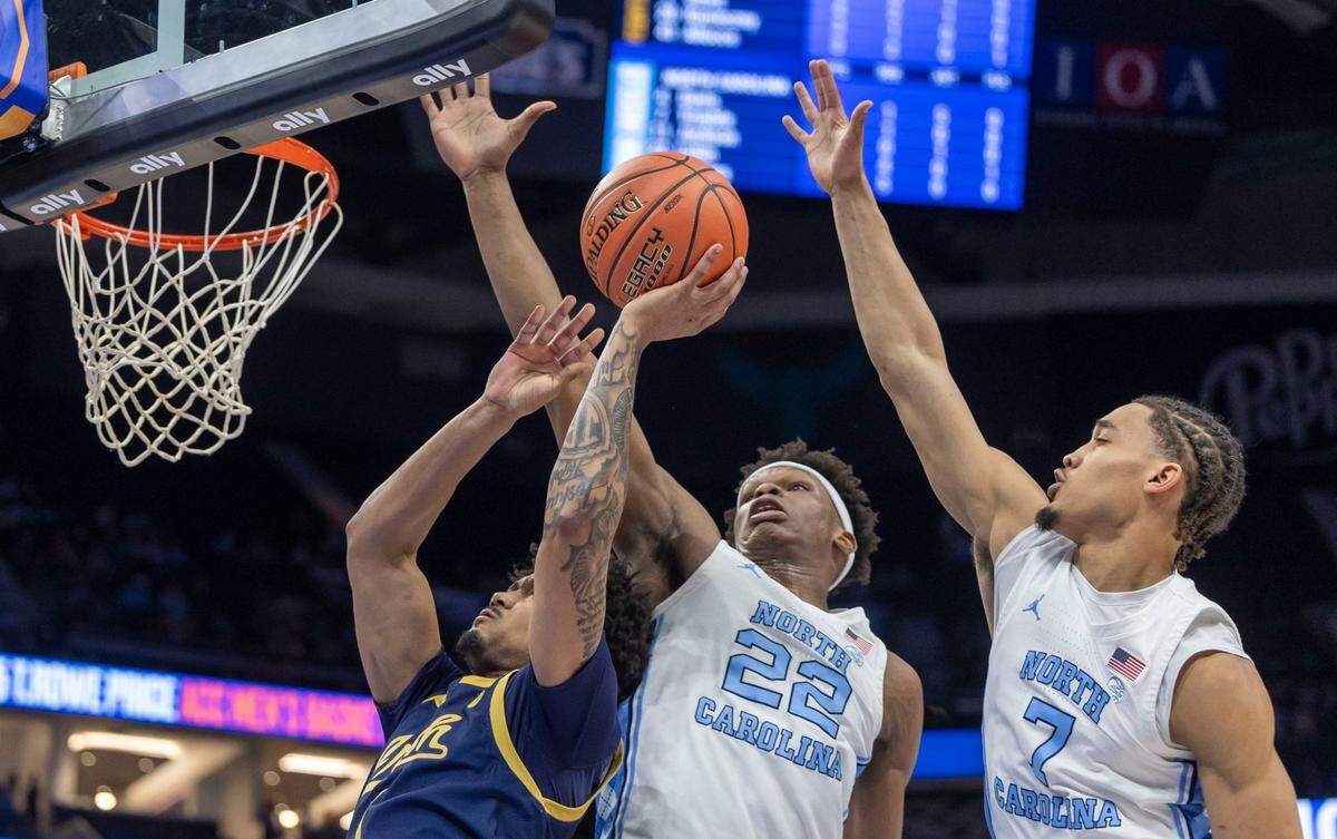 North Carolina forward Ven-Allen Lubin (22) and guard Seth Trimble (7) defend Notre Dame’s Julian Roper II (1) in the first half on Wednesday, March 12, 2025 during the second round of the ACC Tournament at Spectrum Center in Charlotte, N.C.