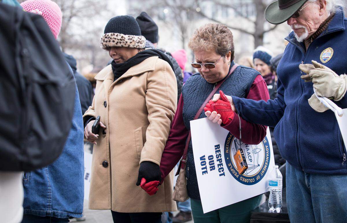 Attendees of the Moral March on Raleigh hold hands in prayer before marching towards the Capitol on Saturday, Feb 9, 2019.
