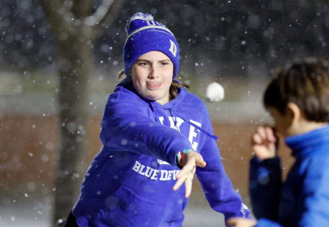 Frances Dowling, 11, throws a snowball at her brother, William, after leaving Reynolds Coliseum on the campus of N.C. State in Raleigh, N.C., Friday, Jan. 10, 2025.