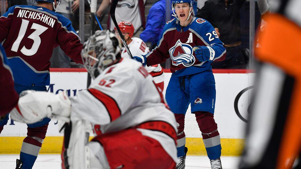 Colorado Avalanche center Nathan MacKinnon (29) celebrates his goal with Colorado Avalanche right wing Valeri Nichushkin (13) as Carolina Hurricanes goaltender Pyotr Kochetkov (52) kneels dejected in the second period at Ball Arena.