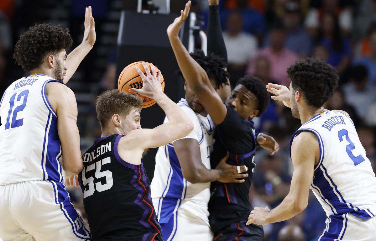 TCU’s Tanner Toolson (55) looks to pass as Cameron Boozer (12), Cayden Boozer (2) and Patrick Ngongba II (21) pressure him during the second half of Duke’s 81-58 victory over TCU in the second round of the NCAA Men’s Basketball Tournament at  Bon Secours Wellness Arena in Greenville, S.C., Saturday, March 21, 2026.