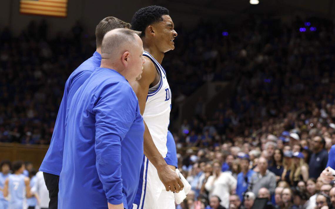 Duke’s Caleb Foster (1) is helped off the floor after being injured during the first half of Duke’s game against UNC at Cameron Indoor Stadium in Durham, N.C., Saturday, March 7, 2026.