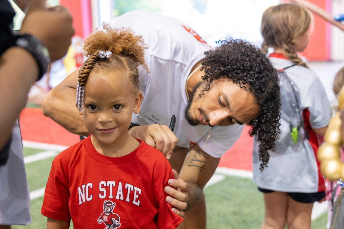N.C. State’s Josh Crabtree autographs 5-year-old Kensli Ray’s shirt during a ‘Meet the Pack’ event with football players and fans at the Close-King Indoor Practice Facility Saturday, Aug. 16, 2023.