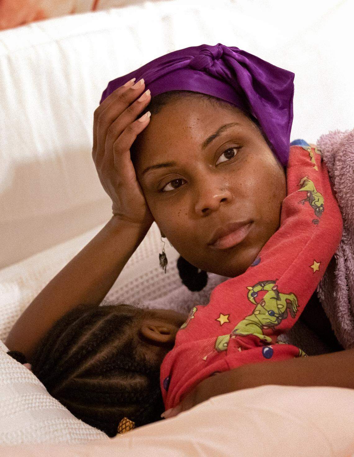 Sheba Everett watches the morning news while allowing her daughter, Hannah Edgerton, 5, an extra few minutes of sleep on Wednesday, Nov. 2, 2022, in Durham, N.C.