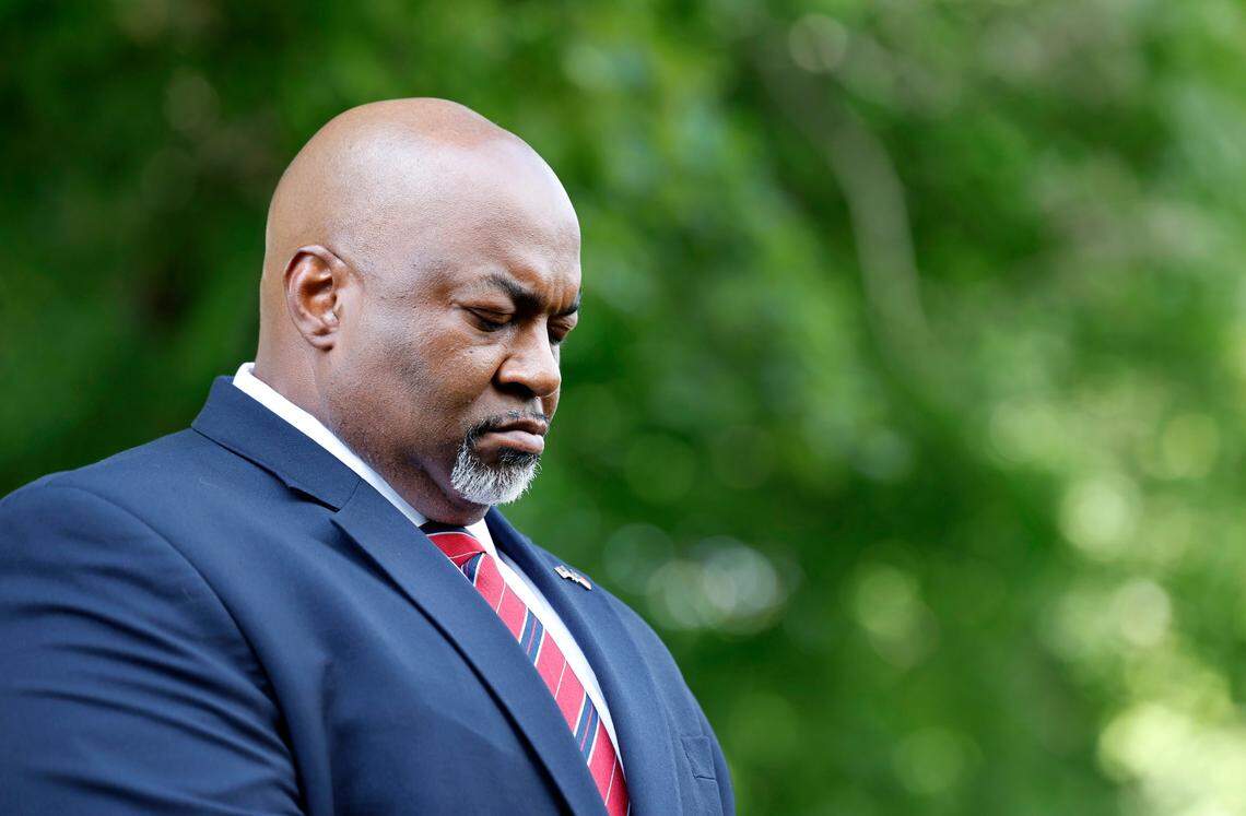 Lt. Gov. Mark Robinson bows his head during the opening prayer at a Moms for Liberty rally outside the Legislative Building in Raleigh, N.C., Wednesday, June 12, 2024.