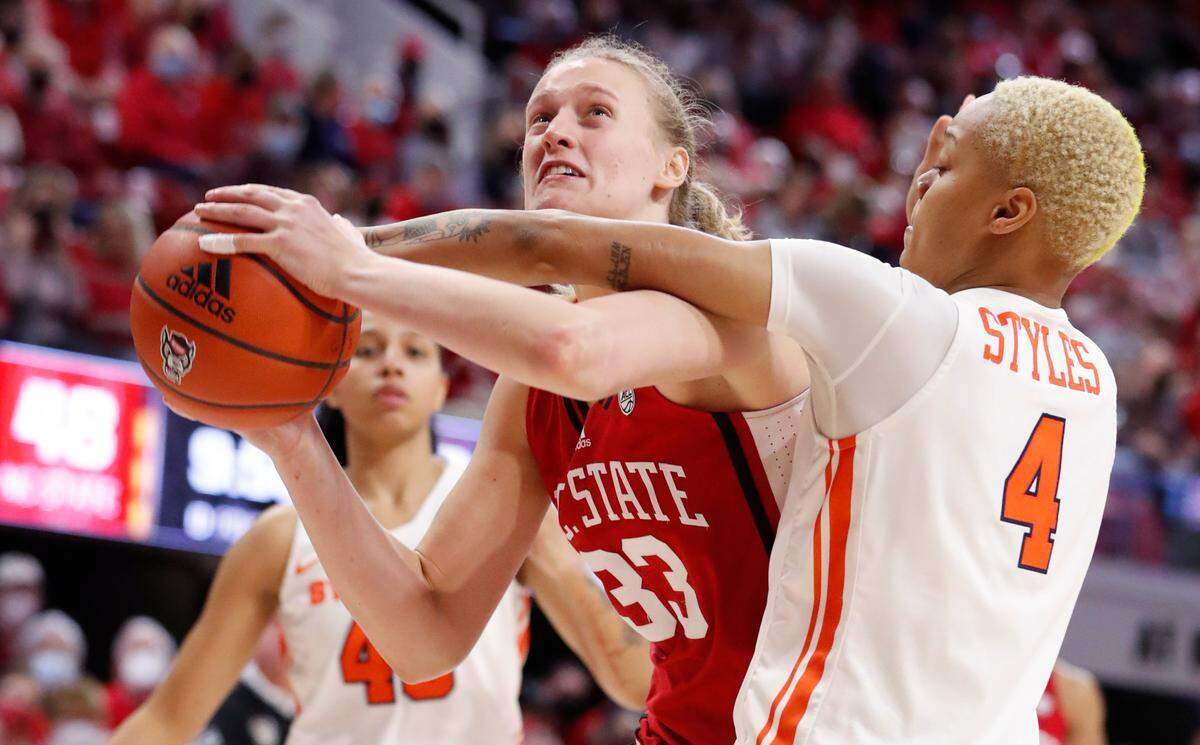 N.C. State’s Elissa Cunane (33) is fouled by Syracuse’s Alaysia Styles (4) during the second half of N.C. State’s 95-53 victory over Syracuse at Reynolds Coliseum in Raleigh, N.C., Sunday, Feb. 20, 2022.
