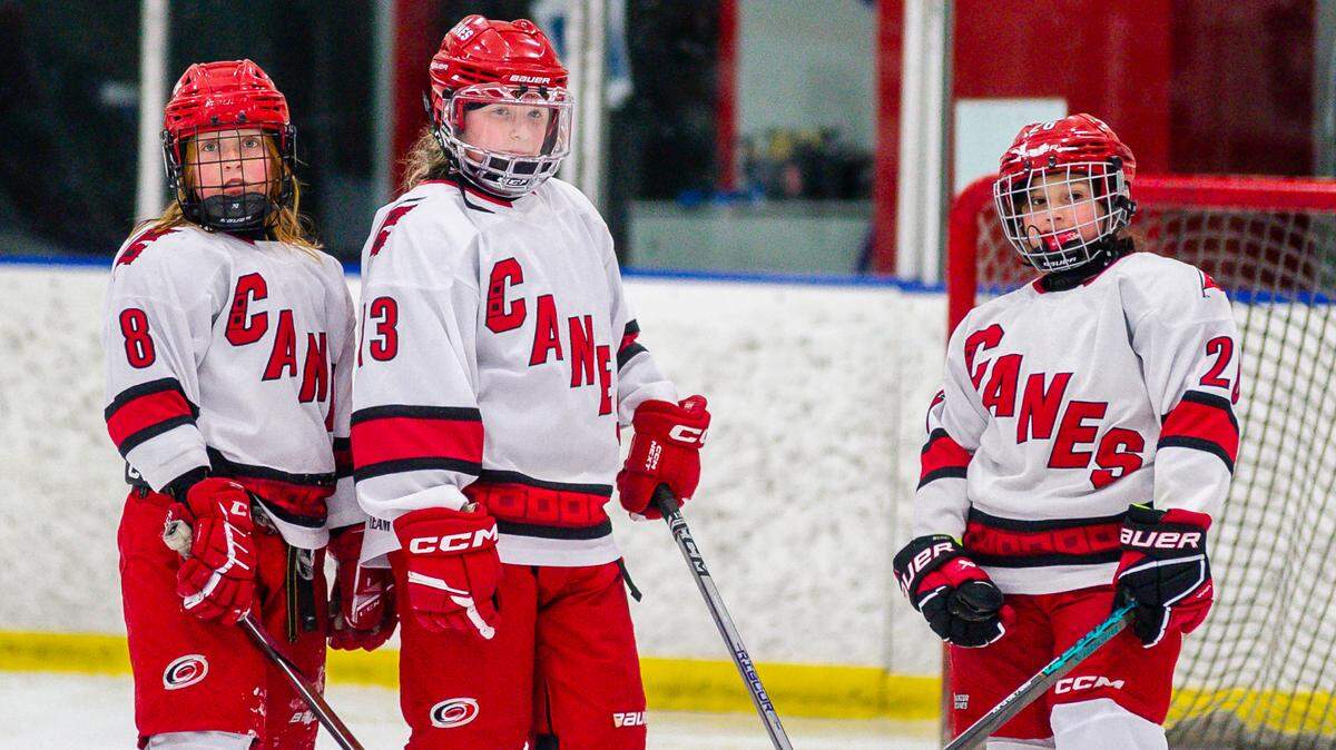 From left, Junior Canes U10 Black girls’ hockey players Eliza Epstein, Erin Pelletier and Skyler Amdur await the start of play during a game this season. The Junior Canes girls’ program has about 200 players registered, nearly a third of all youth hockey-playing girls in North Carolina.