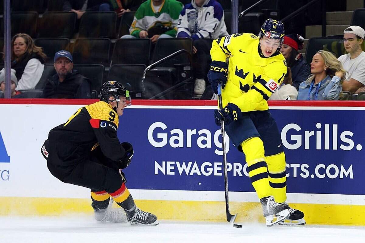 ST PAUL, MINNESOTA - DECEMBER 29: William Hakansson #19 of Sweden passes the puck against Elias Pul #9 of Germany in the first period of a Group A stage game during the IIHF World Junior Hockey Championship at Grand Casino Arena on December 29, 2025 in St Paul, Minnesota. (Photo by David Berding/Getty Images)