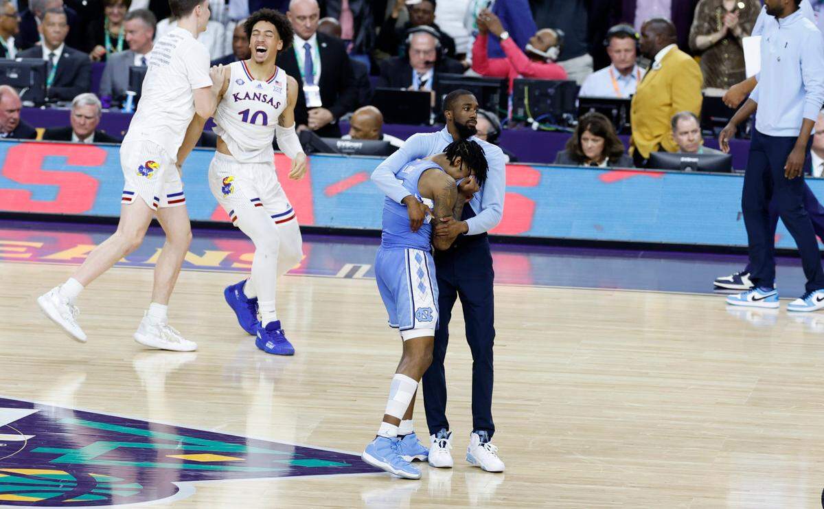 North Carolina guard Caleb Love (2) is comforted by Brandon Robinson after KansasÕ 72-69 victory over UNC in the NCAA MenÕs National Championship at the Caesars Superdome in New Orleans, La., Monday, April 4, 2022.
