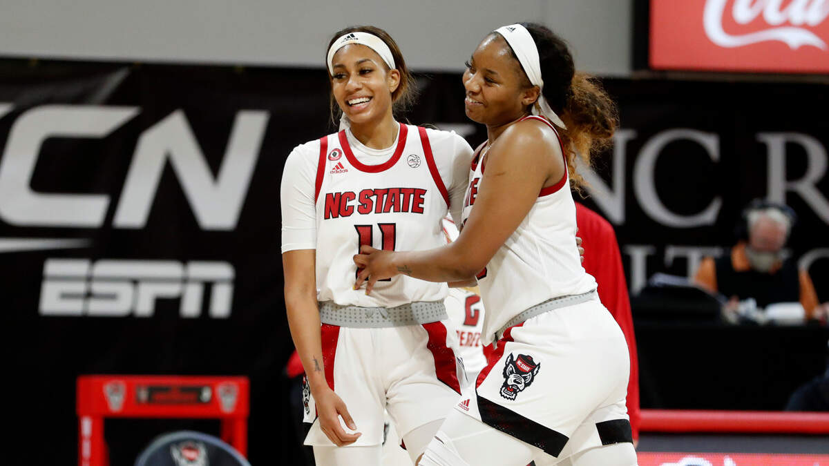 N.C. State’s Kayla Jones (25), right, laughs with Jakia Brown-Turner (11) as a timeout is called during the second half of N.C. State’s 86-65 victory over Clemson at Reynolds Coliseum in Raleigh, N.C., Thursday, February 11, 2021.
