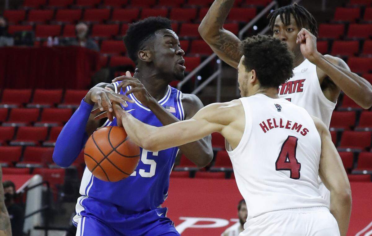 N.C. State’s Jericole Hellems (4) knocks the ball from the hands of Duke’s Mark Williams (15) during the first half of N.C. State’s game against Duke at PNC Arena in Raleigh, N.C., Saturday, February 13, 2021.