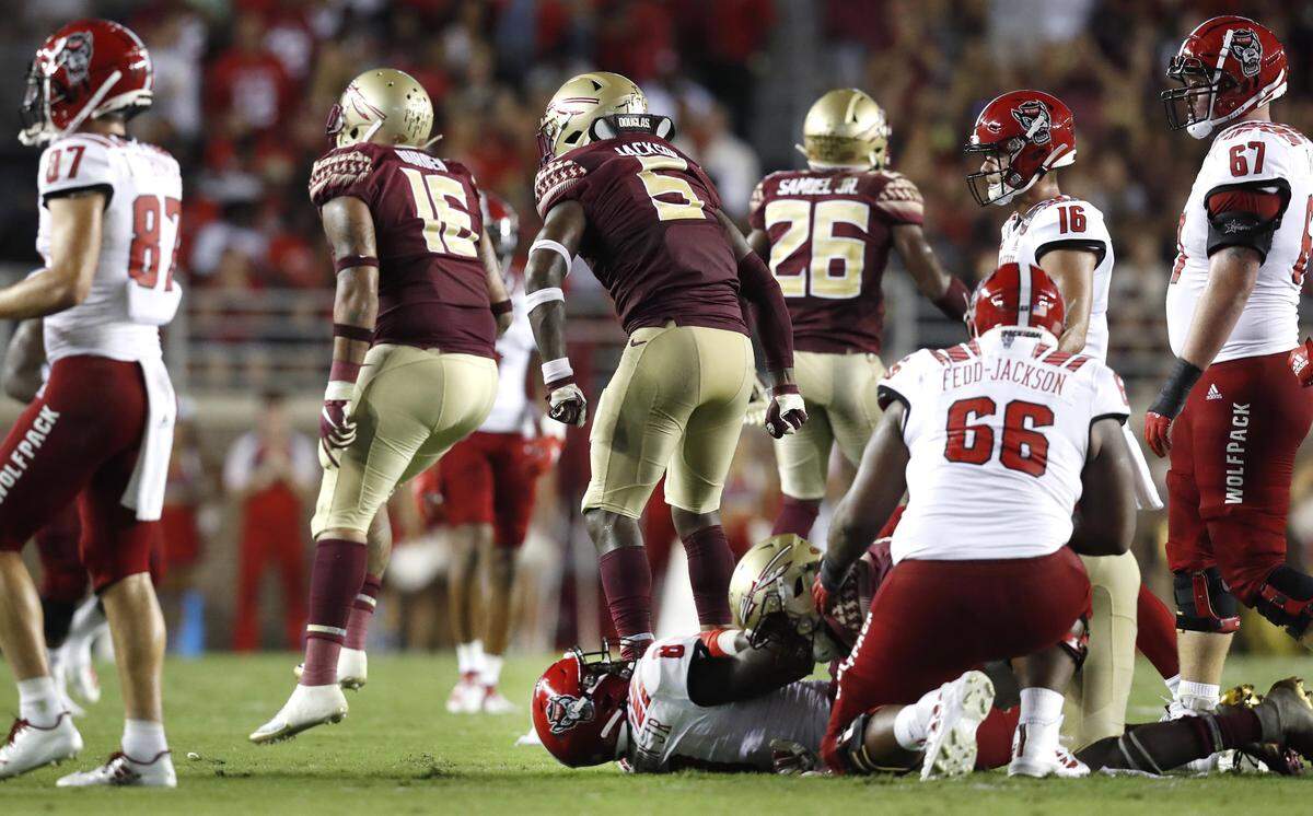 Florida State’s Cory Durden (16) and Dontavious Jackson (5) celebrate after N.C. State running back Ricky Person Jr. (8) was stopped on fourth and one during the first half of N.C. State’s game against Florida State at Doak Campbell Stadium in Tallahassee, Fla., Saturday, Sept. 28, 2019.