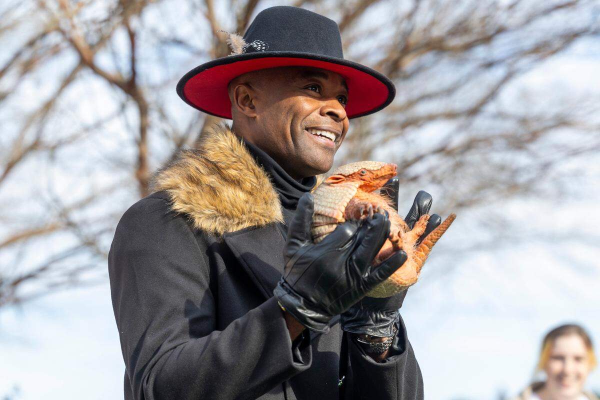 Apex Mayor Jacques Gilbert holds up an armadillo named ‘Sylvia’ after it predicted an early spring according to Gilbert on Groundhog Day, Feb. 2, 2024 at Olive Chapel Elementary School in Apex.